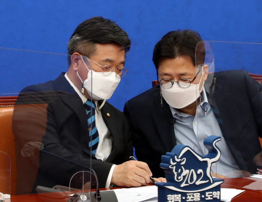 홍익표 민주당 정책위의장이 22일 국회에서 열린 당 정책조정회의에서 윤호중 민주당 비대위원장 겸 원내대표와 대화하고 있다. 연합뉴스